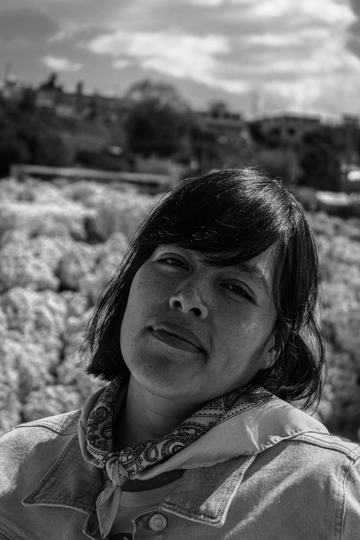 Intimate black and white portrait of a woman in Tepeyahualco, capturing a serene moment outdoors.